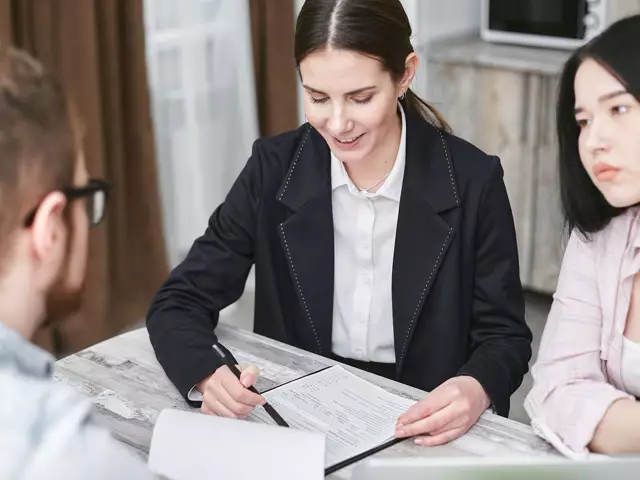 A female adviser going through paperwork with clients at a table