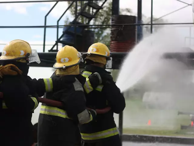Firefighters directing a hose at a fire