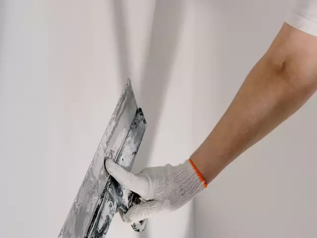 A decorator preparing a wall during repairs